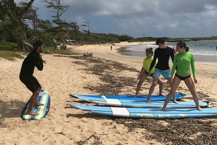 a group of people that are standing in the sand on a beach